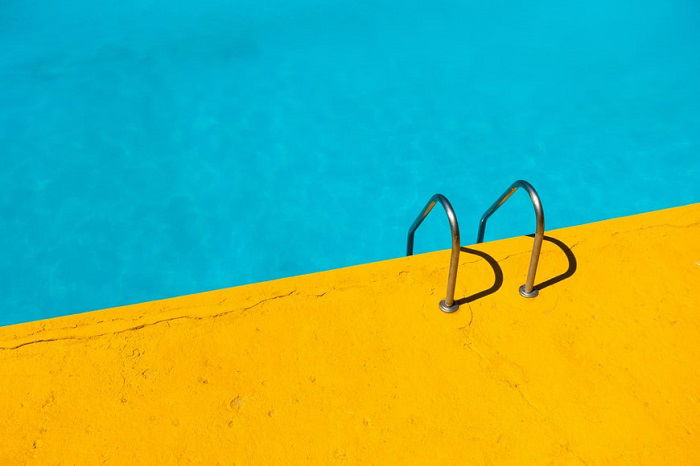 Yellow land next to bright blue swimming pool