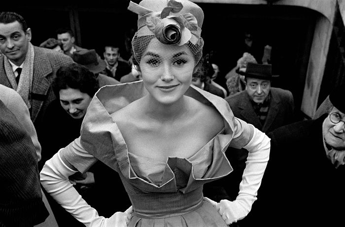 Woman in fancy dress posing on busy public stairs