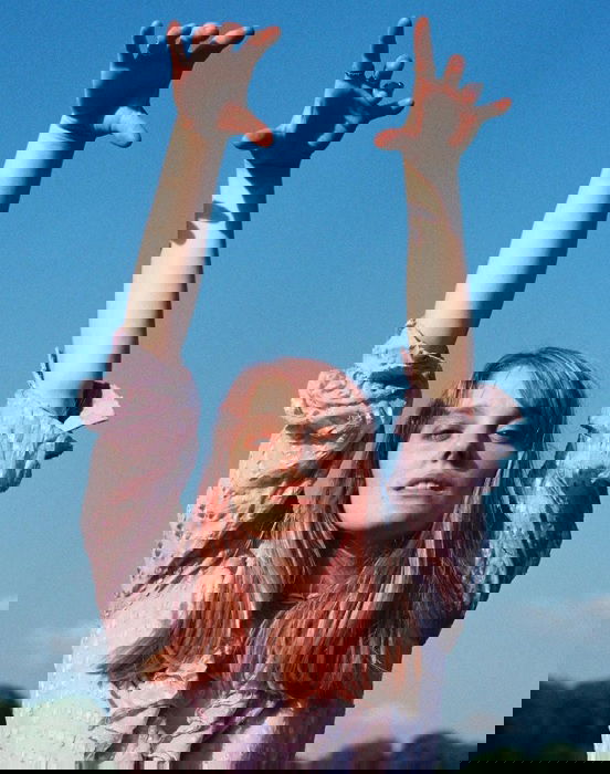portrait of a girl with her hands in the air