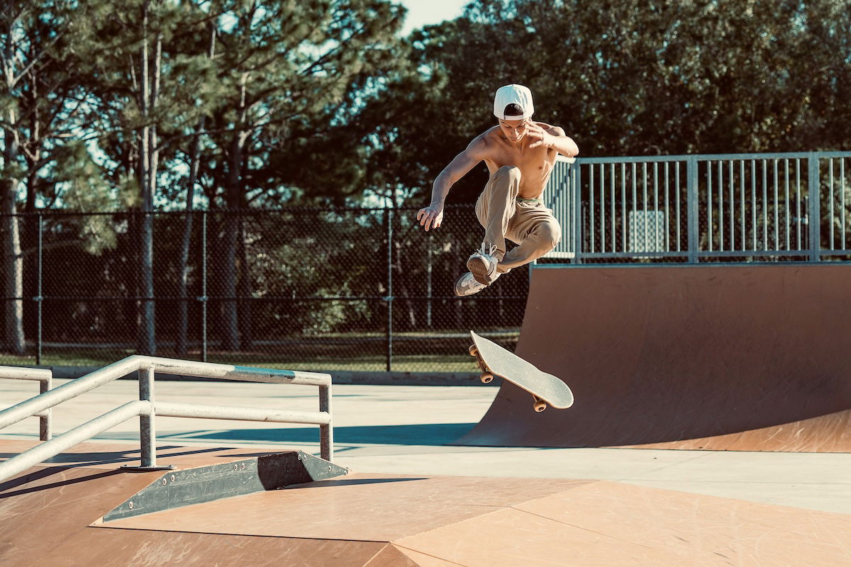 A skateboarder doing a trick in a skate park shot with an f/4.0 aperture